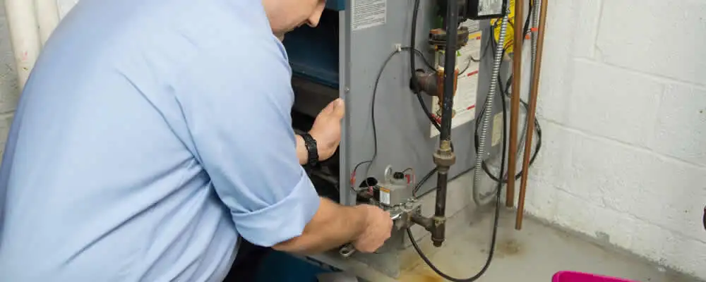 Furnace repair technician inspecting and servicing a home heating system in Phoenix, AZ