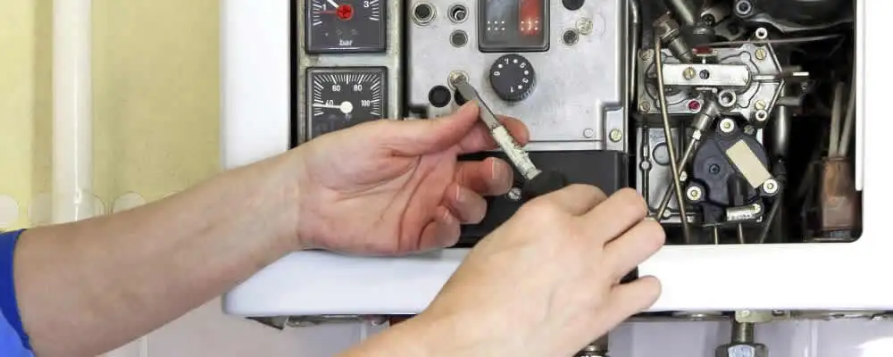 Heating repair technician adjusting boiler controls and components in Phoenix, AZ