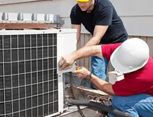 HVAC technicians repairing an outdoor AC unit on a rooftop in Phoenix, AZ